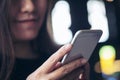 A beautiful Asian girl with smiley face looking and using smart phone in modern cafe Royalty Free Stock Photo