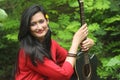 Beautiful asian girl smiling sitting in a beaitiful place holding her guitar