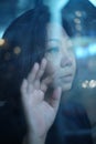 Beautiful Asian girl standing by the window with a sad lonely fe Royalty Free Stock Photo