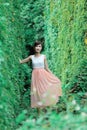 Beautiful Asian girl strolls in the plant wall