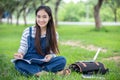 Beautiful Asian girl student holding books and smiling at camera and learning and education concept  on park in summer for relax Royalty Free Stock Photo