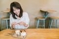 Beautiful Asian girl taking photo of chocolate toast cake, ice-cream, and milk at coffee shop. Dessert or food photograph hobby Royalty Free Stock Photo