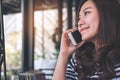 A beautiful Asian girl talking on smart phone with smiley face Royalty Free Stock Photo