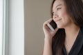 Asian girl talking on smart phone with smiley face in office Royalty Free Stock Photo