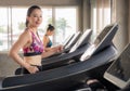 Beautiful asian girl is walking on a treadmill in the gym.She Send your eyes with pleasure in exercise because it makes her shapel