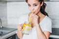 The beautiful asian girl young woman drinking glass jar with lemon water in kitchen, close up Royalty Free Stock Photo