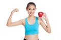 Beautiful Asian healthy girl flexing biceps with red apple Royalty Free Stock Photo