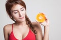 Beautiful Asian healthy girl with orange fruit licks her lips. Royalty Free Stock Photo