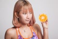 Beautiful Asian healthy girl with orange fruit licks her lips. Royalty Free Stock Photo