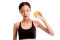 Beautiful Asian healthy girl with orange fruit licks her lips Royalty Free Stock Photo