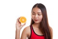 Beautiful Asian healthy girl with orange fruit licks her lips. Royalty Free Stock Photo