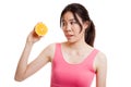 Beautiful Asian healthy girl with orange fruit licks her lips. Royalty Free Stock Photo