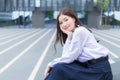 Beautiful Asian high school student girl in the school uniform with braces on her teeth sits and smiles confidently while she Royalty Free Stock Photo