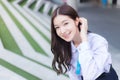 Beautiful Asian high school student girl in the school uniform with braces on her teeth stands and smiles confidently while she Royalty Free Stock Photo