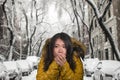 Beautiful Asian Korean woman feeling cold and chilly freezing feeling cold in Winter weather wearing yellow jacket with fur hood Royalty Free Stock Photo