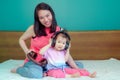 A beautiful Asian lady mother is pregnant. Take a big headset Come to the stomach Let the child in the belly listen Have a little Royalty Free Stock Photo