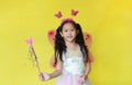 Beautiful asian little child girl dressed in fairy costume isolated on yellow background Royalty Free Stock Photo