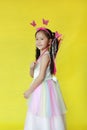 Beautiful asian little child girl dressed in fairy costume isolated on yellow background Royalty Free Stock Photo