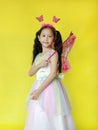 Beautiful asian little girl dressed in fairy costume isolated over yellow background Royalty Free Stock Photo