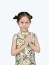 Beautiful Asian little girl wearing cheongsam with smiling and welcome gesture celebrating for happy Chinese New Year isolated on Royalty Free Stock Photo