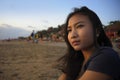 Beautiful Asian lonely woman looking to infinity lost in her thoughts sad and thoughtful sitting on sand beach Royalty Free Stock Photo