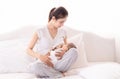 Beautiful Asian mother breast feeding her baby on bed at home, mom holding and looking toddler with love and tender. Milk from mom Royalty Free Stock Photo