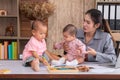 Beautiful Asian mother confuse multi task, single mom cannot work while kids playing, work from home fussy taking care chaotic Royalty Free Stock Photo