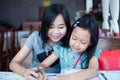 Beautiful asian mother helping her daughter with homework Royalty Free Stock Photo