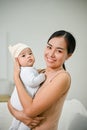 Beautiful Asian Mother holding her baby boy while relaxing on the sofa Royalty Free Stock Photo