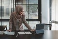 Beautiful asian muslim business woman brown hijab sitting and working with laptop computer at modern office Royalty Free Stock Photo