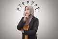 Beautiful Asian muslim business woman wearing hijab looking up and thinking with question mark, businesswoman confused of a