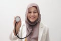 Beautiful Asian muslim female medical doctor wearing hijab want to make examination with stethoscope, smiling to camera