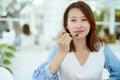 A beautiful Asian portrait is taking a spoonful of cakes on the table and eating them with happy eyes and expressions in the Royalty Free Stock Photo