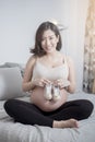 Beautiful asian pregnant woman expecting her baby with small shoes Royalty Free Stock Photo