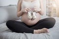 Beautiful asian pregnant woman expecting her baby with small shoes Royalty Free Stock Photo