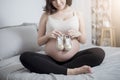 Beautiful asian pregnant woman expecting her baby with small shoes Royalty Free Stock Photo