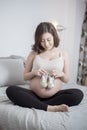 Beautiful asian pregnant woman expecting her baby with small shoes Royalty Free Stock Photo