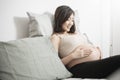 Beautiful asian pregnant woman lying on her bed, touching  big belly Royalty Free Stock Photo