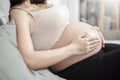 Beautiful asian pregnant woman lying on her bed, touching  big belly Royalty Free Stock Photo