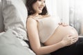 Beautiful asian pregnant woman lying on her bed, touching  big belly Royalty Free Stock Photo