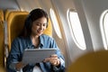 Beautiful asian travel woman watching movie on digital tablet in airplane Royalty Free Stock Photo