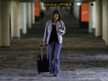 Beautiful Asian traveler wearing casual dress holding bag using smartphone and walking in airport terminal walkway Royalty Free Stock Photo