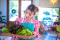 Beautiful asian waitress looking a wooden tray full of organic vegetables with a smile, Harvesting, Smart farm