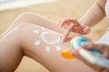 Beautiful Asian woman apply sun protection cream on tanned on leg at tropical beach Royalty Free Stock Photo