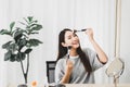 Beautiful asian woman applying and makeup on her face with brush,Beauty concept