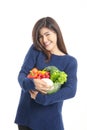 Beautiful asian woman A bright, healthy smile holds a glass bowl of organic vegetables.