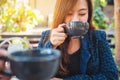 A beautiful asian woman clinking and drinking coffee with friend in cafe Royalty Free Stock Photo