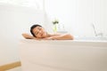Beautiful asian woman close eye and relax on jacuzzi bathtub in the morning,Female lying body in water at hotel,Copy space for tex Royalty Free Stock Photo