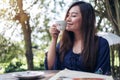 A beautiful Asian woman close her eyes smelling and drinking hot coffee with feeling good Royalty Free Stock Photo