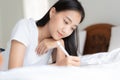 Beautiful Asian woman is drawing on the bed. Asian girl using tablet to learn to draw at her home